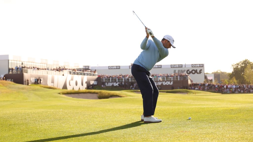 Groups of golfers tee off simultaneously on different holes during a shotgun start tournament, capturing the energetic launch.