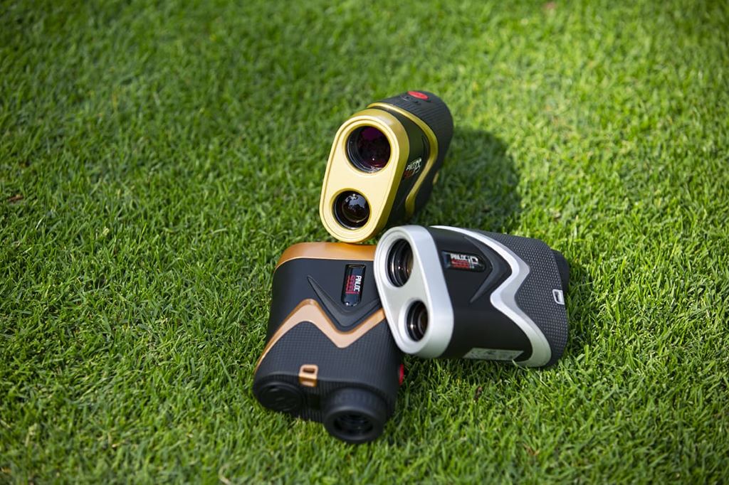 Handheld golf rangefinder measuring distance to flagstick on a sunny golf course.