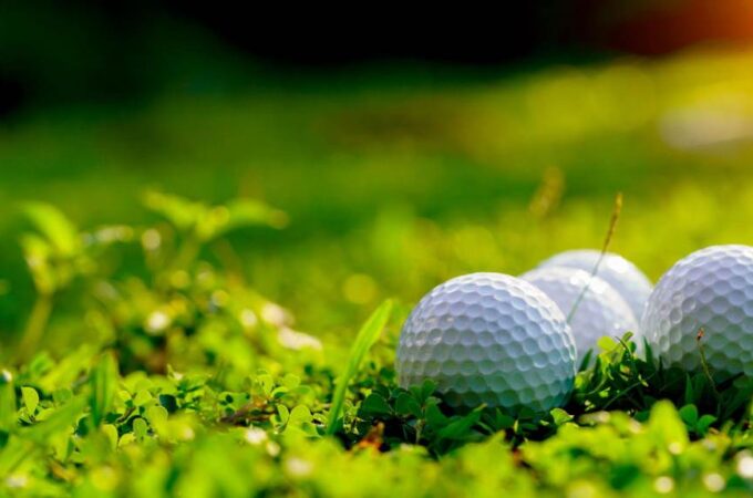 Golf ball on green grass in the evening golf course