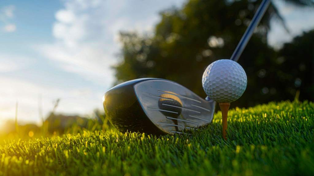 Golf clubs and balls on a green lawn in a beautiful golf course with morning sunshine