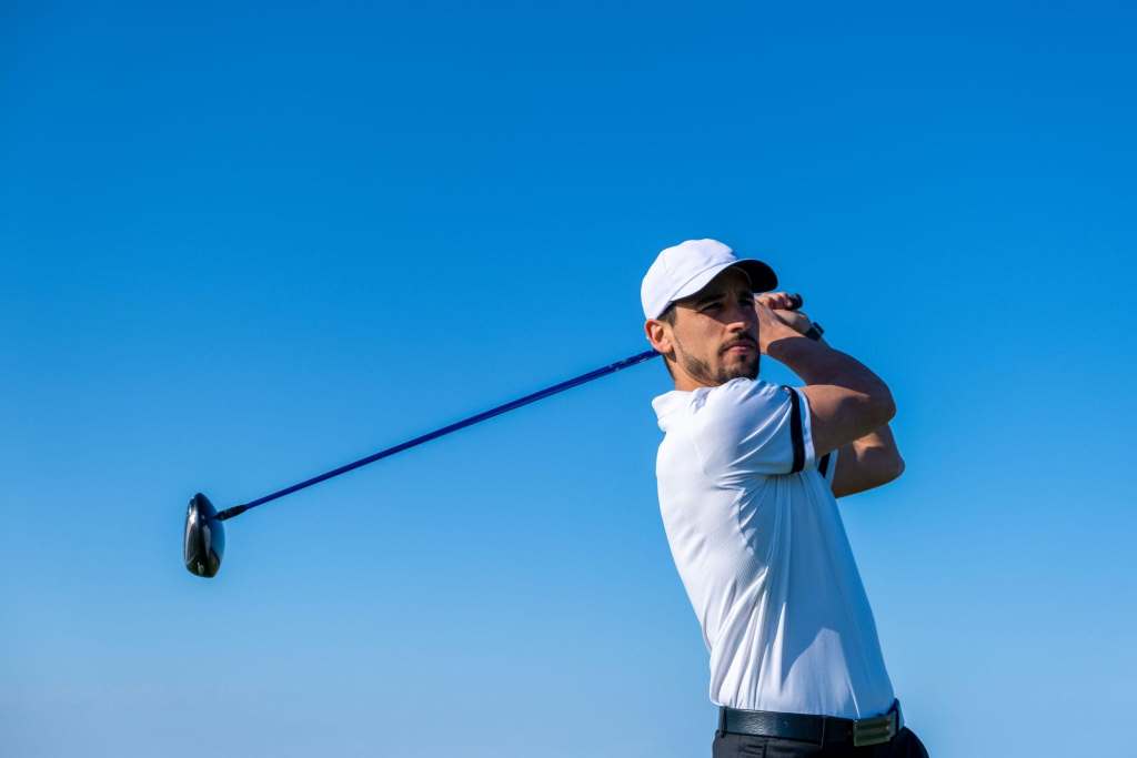 Golfer wearing breathable wide brim hat under bright sun on golf course