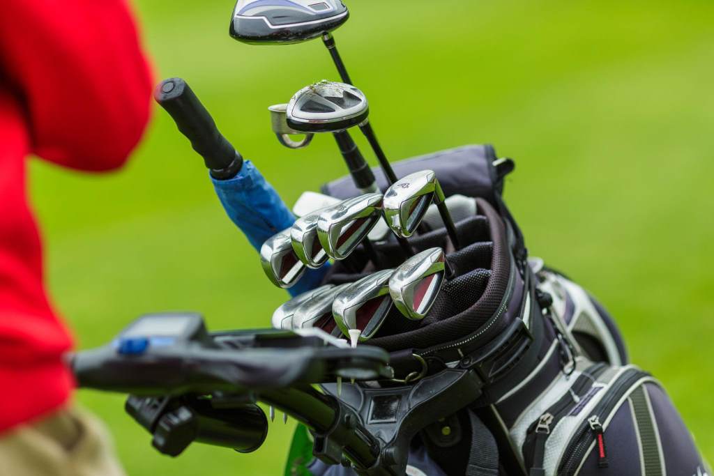 Set of Golf Clubs in Bag on Green Field