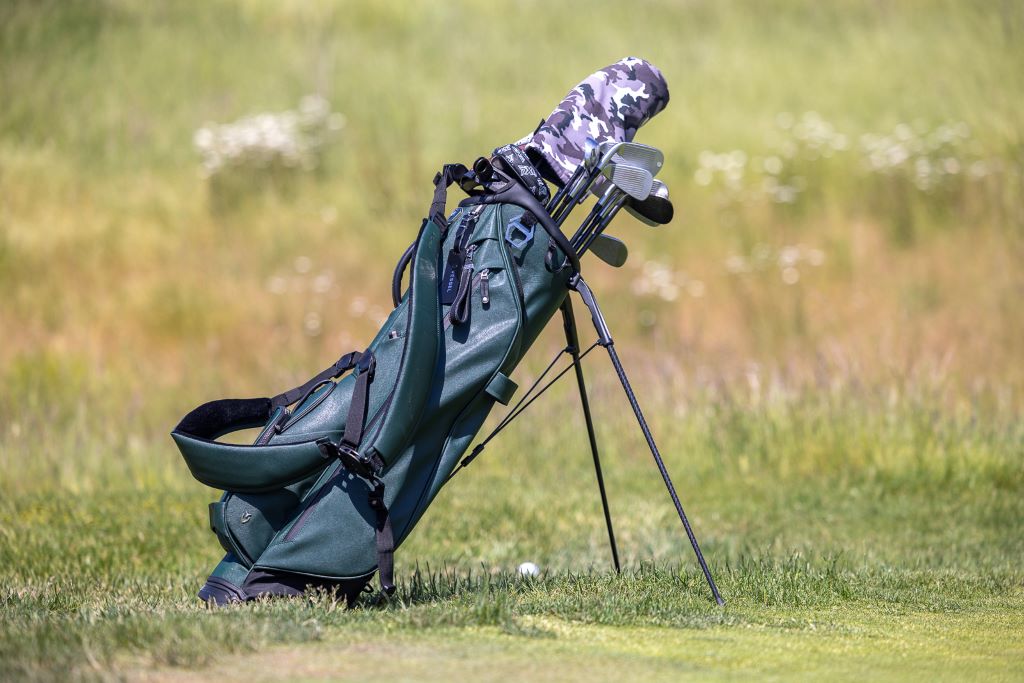 Lightweight golf bag with multiple club compartments placed on a golf course.