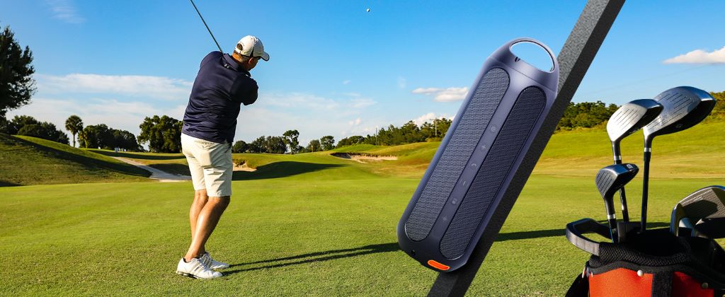 Golfer enjoying music with a compact portable speaker during a round of golf